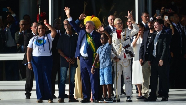 No alto da rampa do Palácio do Planalto, representantes do povo brasileiro entregaram e colocaram a faixa no presidente Lula, após ser empossado (Foto: Marcelo Camargo/Agência Brasil).