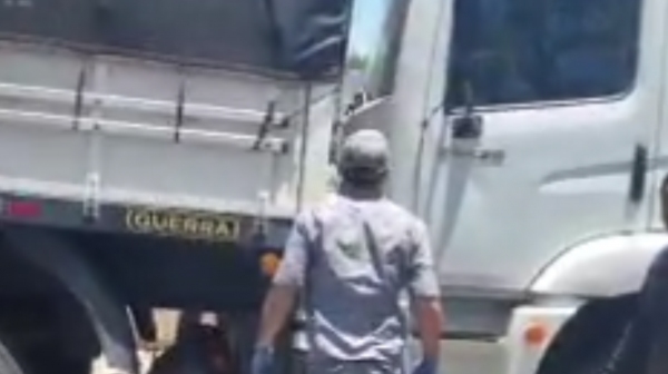 Bombeiros prestam atendimento � v�tima prensada entre dois caminh�es (Reprodu��o).