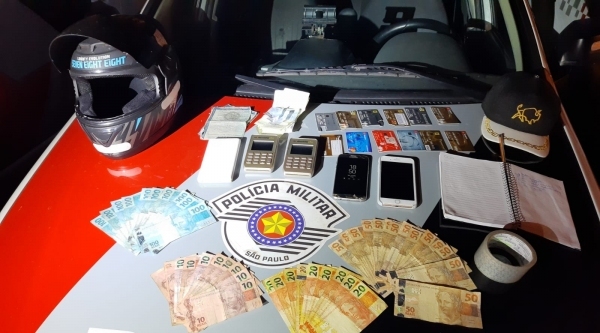 A��o da Policia Militar termina com homem preso. Com o golpista, foram apreendidos dinheiro e cart�es das v�timas, m�quinas de cart�o, celulares, uma moto e outros objetos (Foto: Cedida/PM).